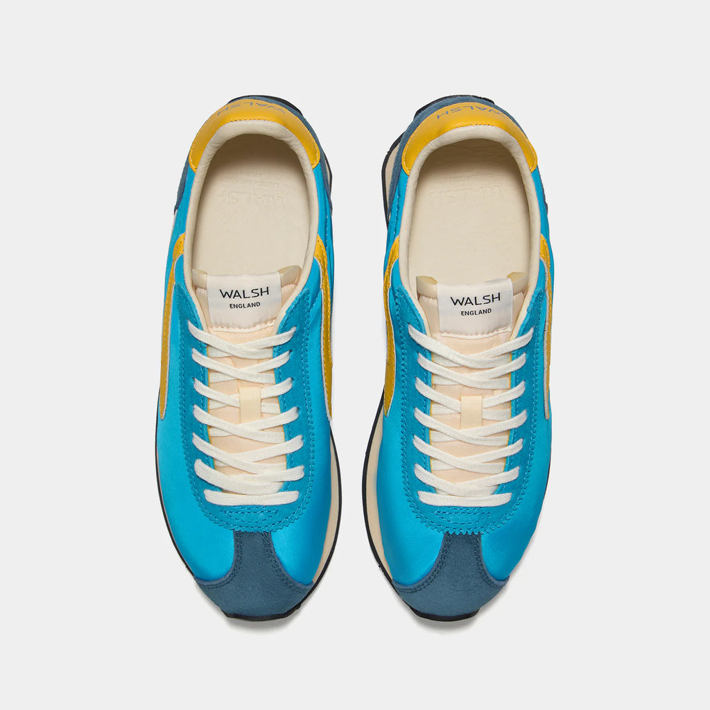 Top-down view of the London Qua Blue sneaker, showing the refined 1970s Scintilla silhouette and weather-resistant material textures.