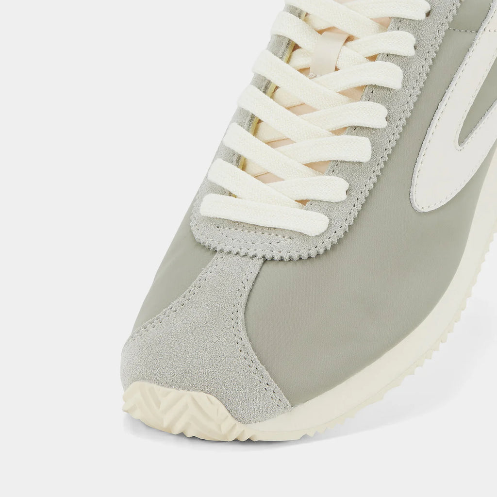 Close-up view of the London Beige and Bean Green sneaker, showing the refined 1970s Scintilla silhouette and weather-resistant material textures.